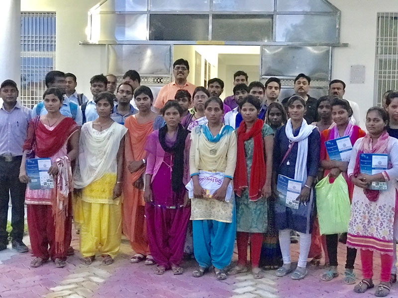 A group of young trainees holding course booklets outside the SIET building